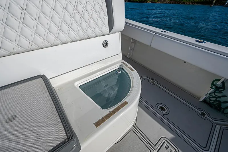 Slide: The Image of 2011 Yellowfin 39 Offshore boat interior with cushioned seating and storage compartment. - 22