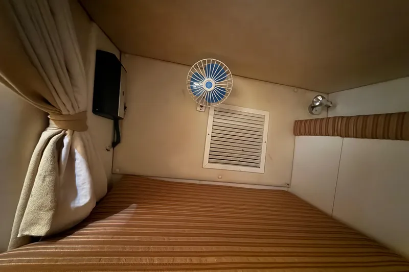 Slide: The Image of 2007 Hydra-Sports Vector 2900 VX cabin interior with striped bedding and small fan. - 134