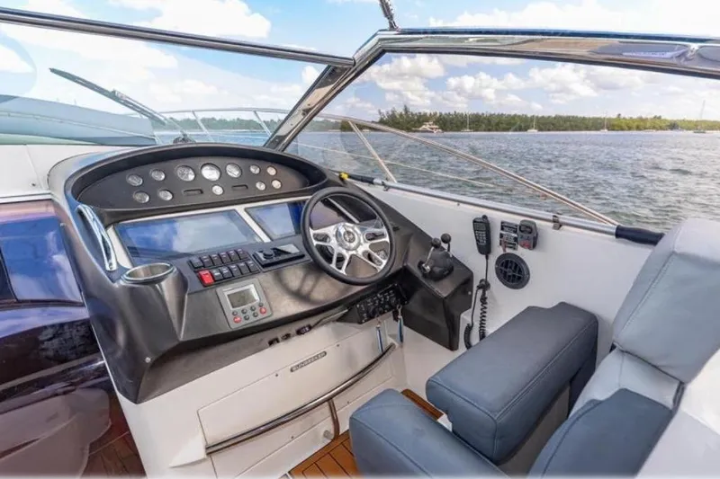Slide: The Image of Helm of 2006 Sunseeker Portofino 47 yacht with modern controls and scenic water view. - 7