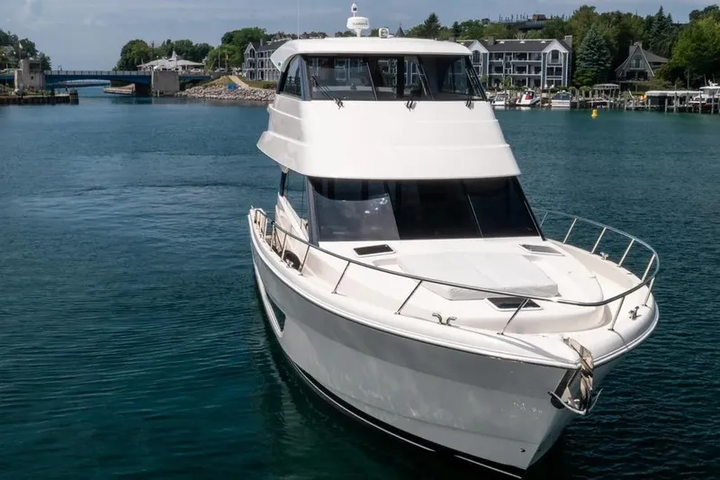 Slide: The Image of 2024 Maritimo M55 yacht cruising in a scenic harbor setting. - 2