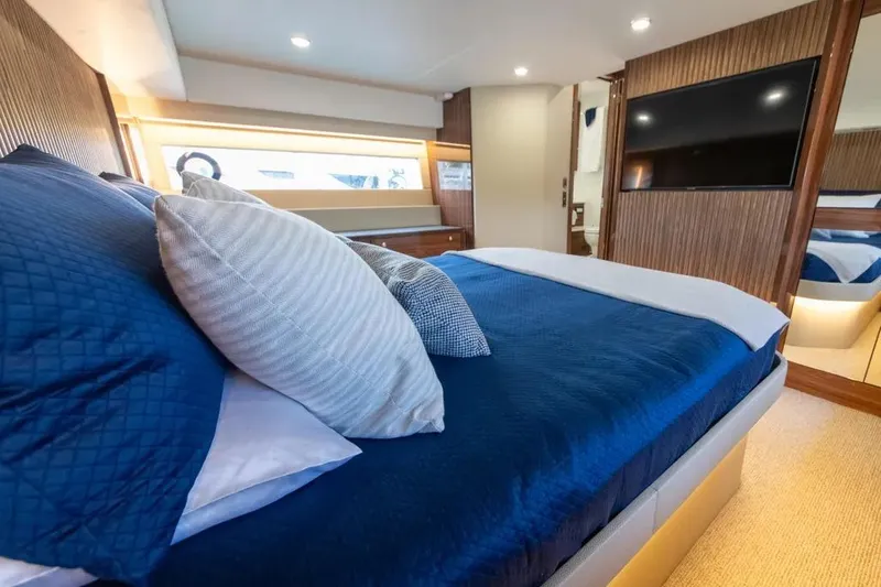 Slide: The Image of Luxurious 2024 Maritimo M55 yacht bedroom with blue bedding and modern decor. - 20