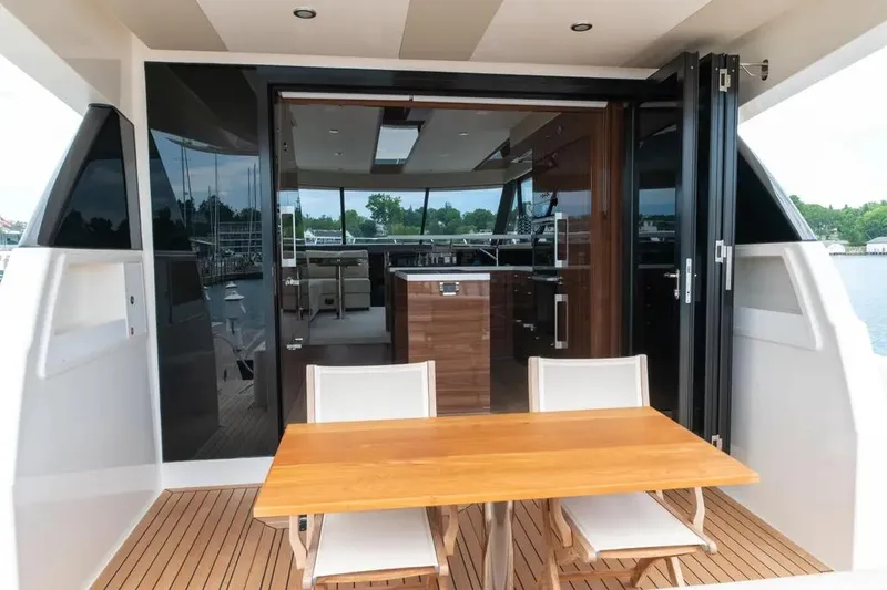 Slide: The Image of 2024 Maritimo M55 yacht interior with wooden table and chairs on deck. - 46