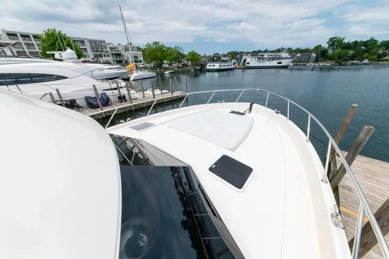 Slide: The Image of 2024 Maritimo M55 yacht docked at a marina with scenic waterfront views. - 49
