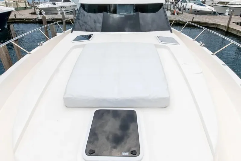 Slide: The Image of 2024 Maritimo M55 yacht deck with sunpad and sleek design in marina setting. - 51