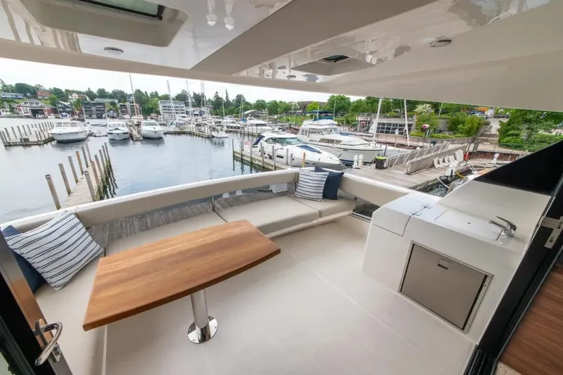 Slide: The Image of 2024 Maritimo M55 yacht deck with seating, table, and marina view. - 71