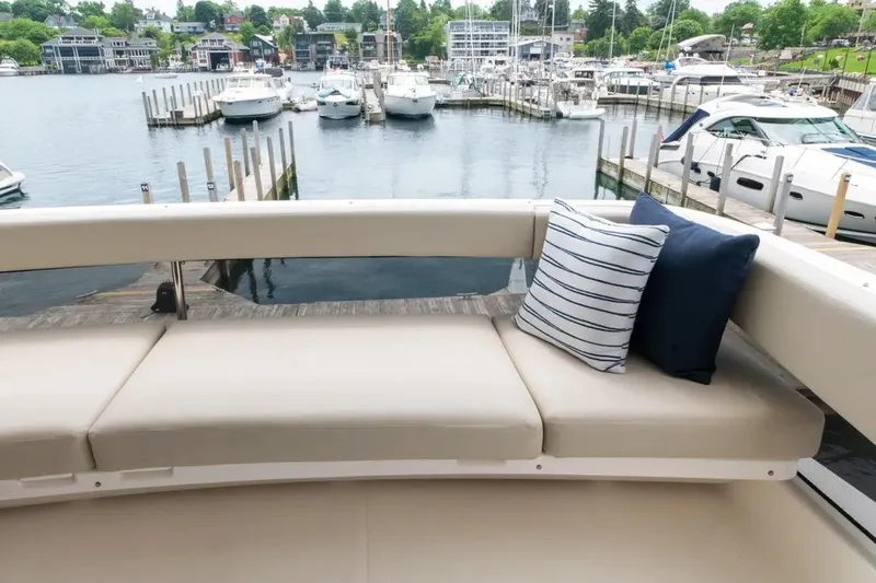 Slide: The Image of 2024 Maritimo M55 yacht with cushioned seating, docked at a marina. - 82