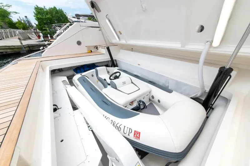 Slide: The Image of 2024 Maritimo M55 yacht with tender storage compartment open, showcasing inflatable boat. - 86