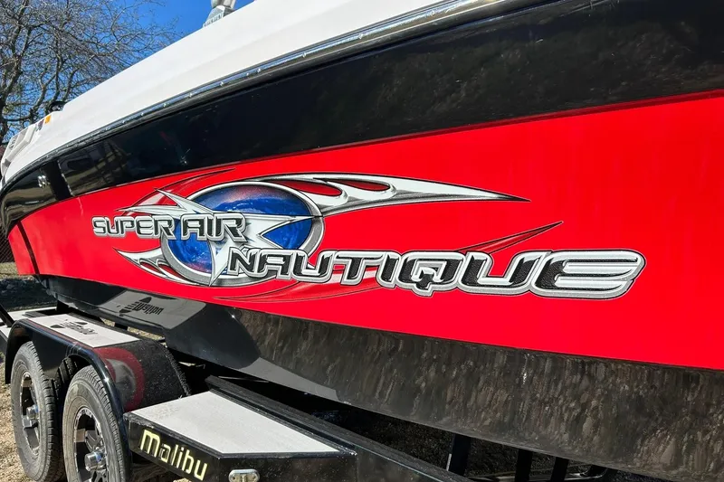 Slide: The Image of 2007 Nautique Super Air Nautique 220 boat with vibrant red and black design. - 11