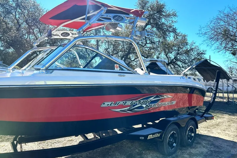 Slide: The Image of 2007 Nautique Super Air Nautique 220 boat with red and black design on trailer. - 17