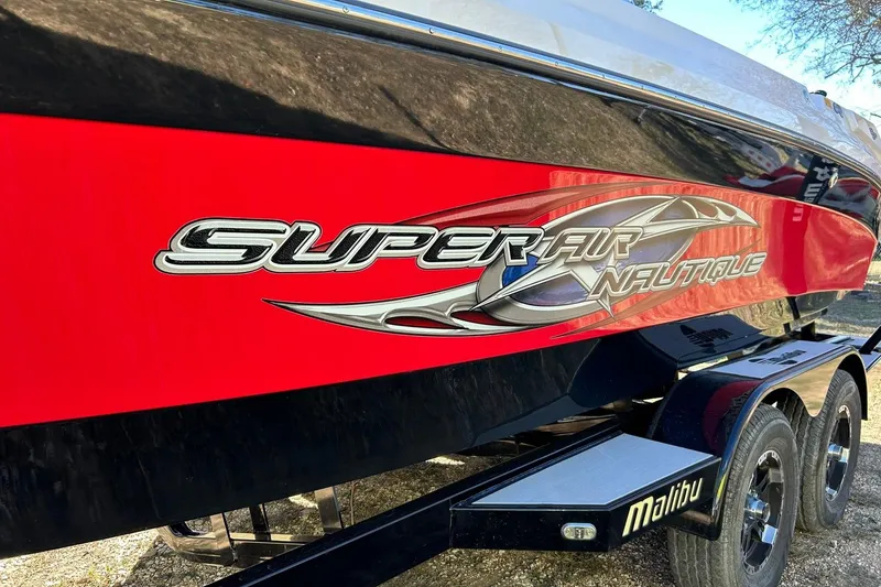 Slide: The Image of 2007 Nautique Super Air Nautique 220 boat with red and black design on trailer. - 18
