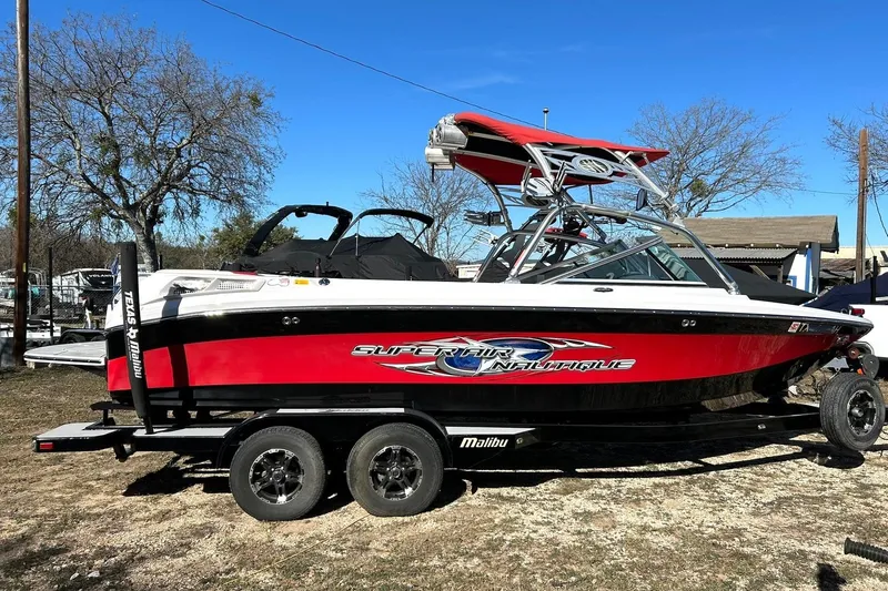 Slide: The Image of 2007 Nautique Super Air Nautique 220 boat on trailer, red and black design. - 7