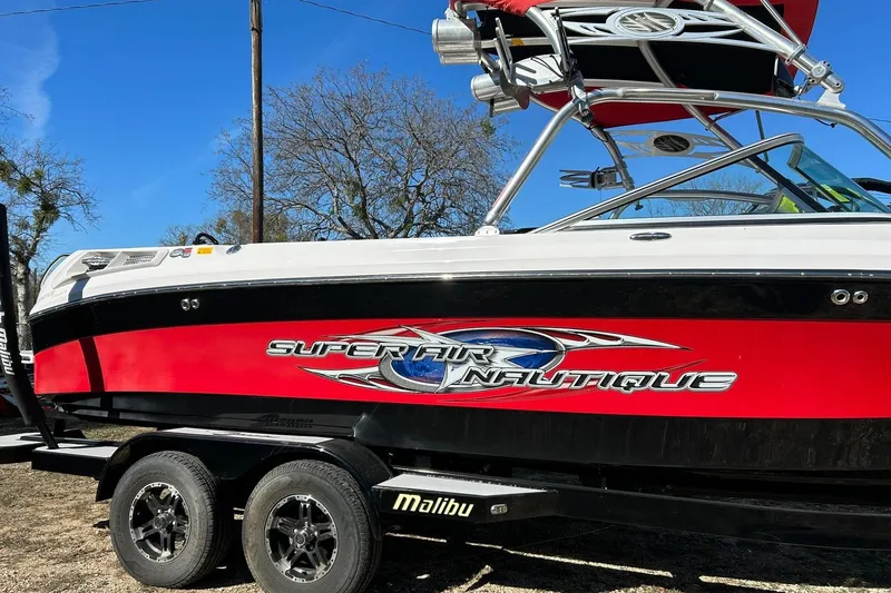 Slide: The Image of 2007 Nautique Super Air Nautique 220 boat with red and black design on trailer. - 8