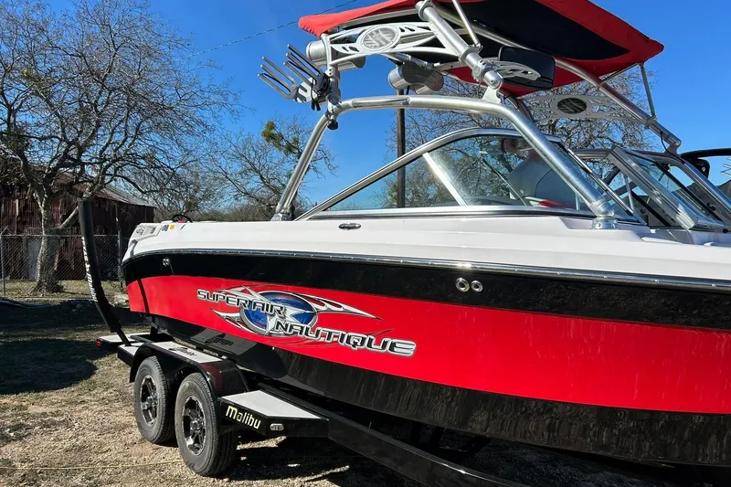 Slide: The Image of 2007 Nautique Super Air Nautique 220 boat with red and black design on trailer. - 9