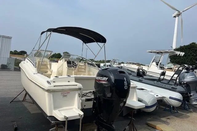 Slide: The Image of 2018 Scout Dorado 210 boat with Mercury outboard motor, docked near other boats. - 1