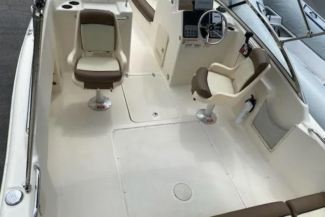 Slide: The Image of 2018 Scout Dorado 210 boat interior with two swivel seats and steering console. - 10