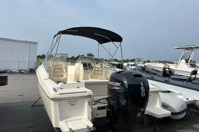 Slide: The Image of 2018 Scout Dorado 210 boat with Mercury 150 engine, parked outdoors. - 2