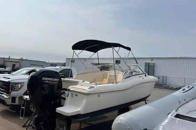 Slide: The Image of 2018 Scout Dorado 210 boat with Mercury engine, parked outdoors. - 3