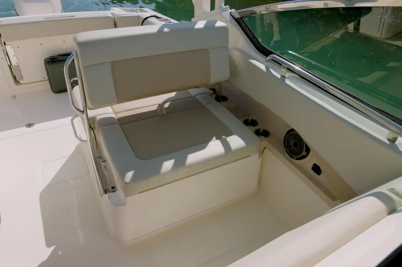 Slide: The Image of 2022 Boston Whaler 240 Vantage boat interior with cushioned seating and cup holders. - 12