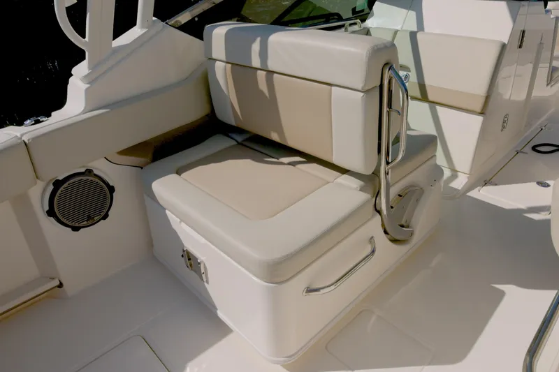 Slide: The Image of 2022 Boston Whaler 240 Vantage boat interior seating with beige cushions and stainless steel accents. - 14