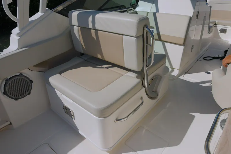 Slide: The Image of 2022 Boston Whaler 240 Vantage boat interior with beige seating and storage. - 15