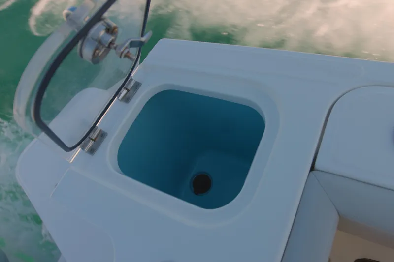Slide: The Image of Open storage compartment on 2022 Boston Whaler 240 Vantage boat, with ocean background. - 16
