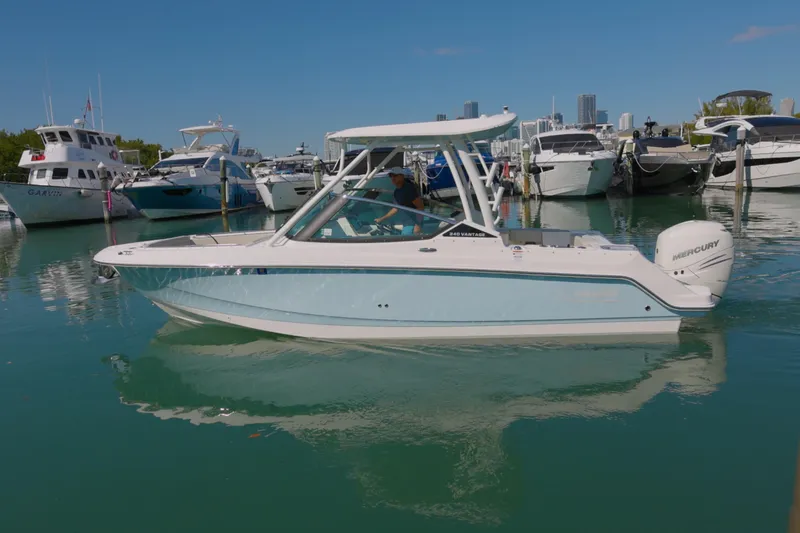 Slide: The Image of 2022 Boston Whaler 240 Vantage boat docked in a marina with other vessels. - 2