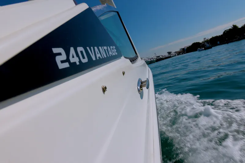 Slide: The Image of 2022 Boston Whaler 240 Vantage cruising on clear blue water. - 4
