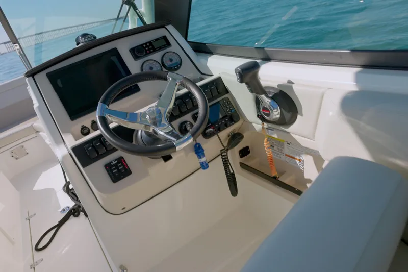 Slide: The Image of 2022 Boston Whaler 240 Vantage helm with steering wheel and controls, ocean view. - 7