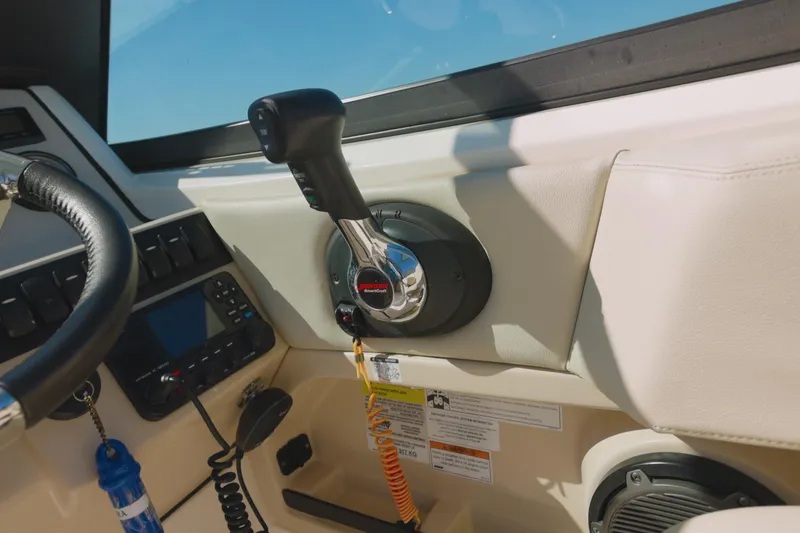 Slide: The Image of Control panel of 2022 Boston Whaler 240 Vantage boat, featuring throttle and steering wheel. - 9