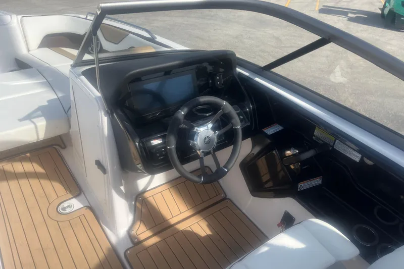 Slide: The Image of 2022 Yamaha Boats 212SE cockpit with steering wheel and dashboard, featuring sleek design and wood accents. - 6