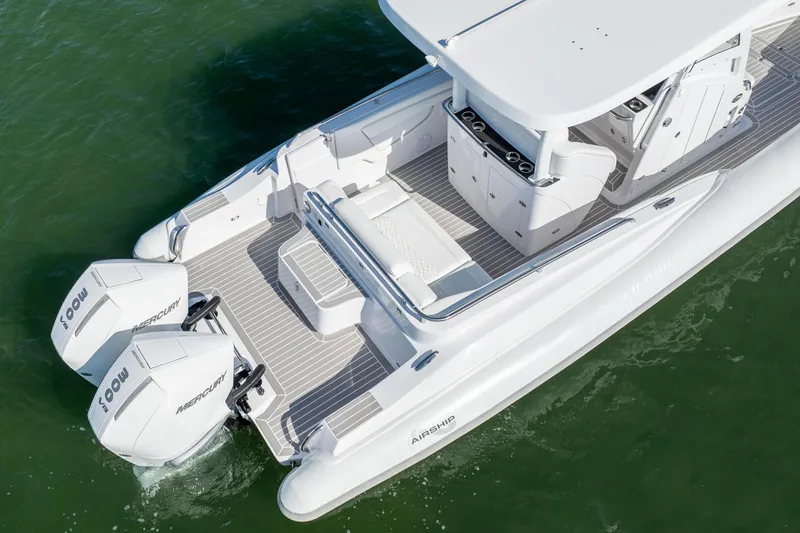 Slide: The Image of 2025 Airship 340 boat with dual Mercury engines on calm water. - 13