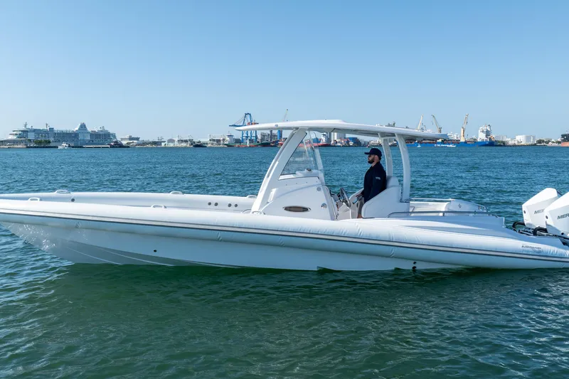 Slide: The Image of 2025 Airship 340 boat on water, with a person at the helm, port in background. - 15