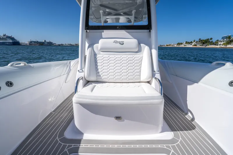 Slide: The Image of 2025 Airship 340 boat interior with white seating, on calm water, under clear blue sky. - 27