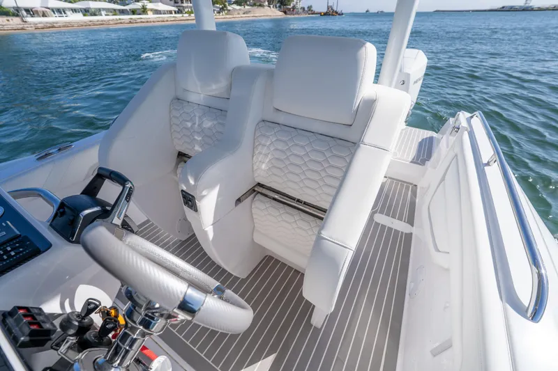 Slide: The Image of Luxurious white seating on 2025 Airship 340 boat, featuring modern design and ocean backdrop. - 35