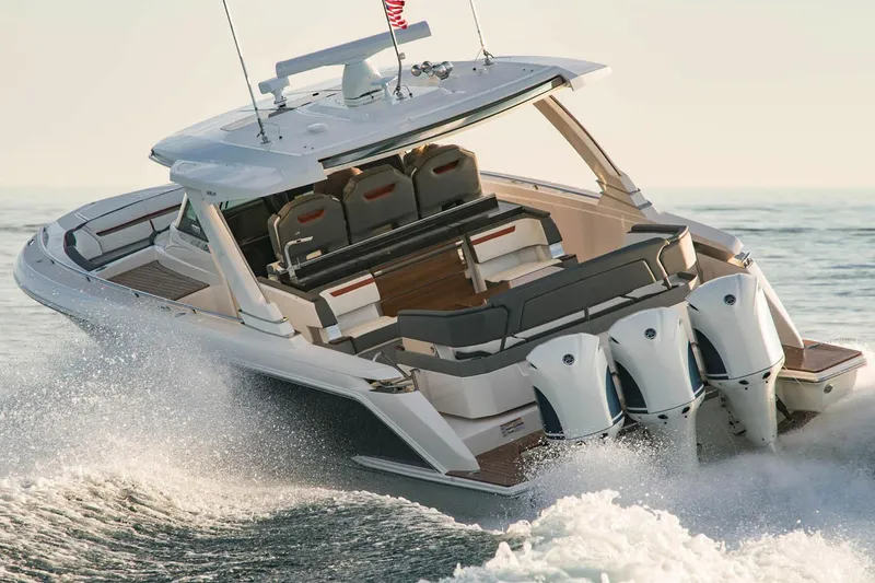 Slide: The Image of 2021 Tiara Sport 38 LX boat on water, with Yamaha engines, near waterfront homes. - 6