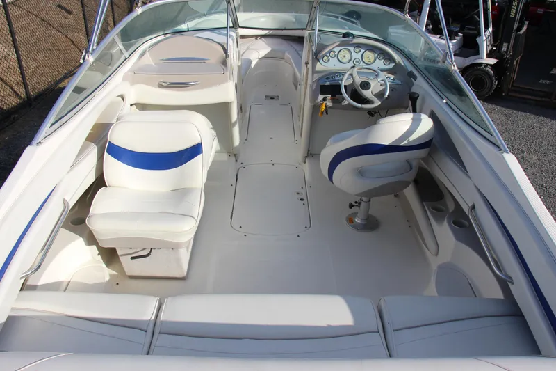 Slide: The Image of 2004 Maxum 2400 SR boat interior with white and blue seating, steering wheel, and dashboard. - 10