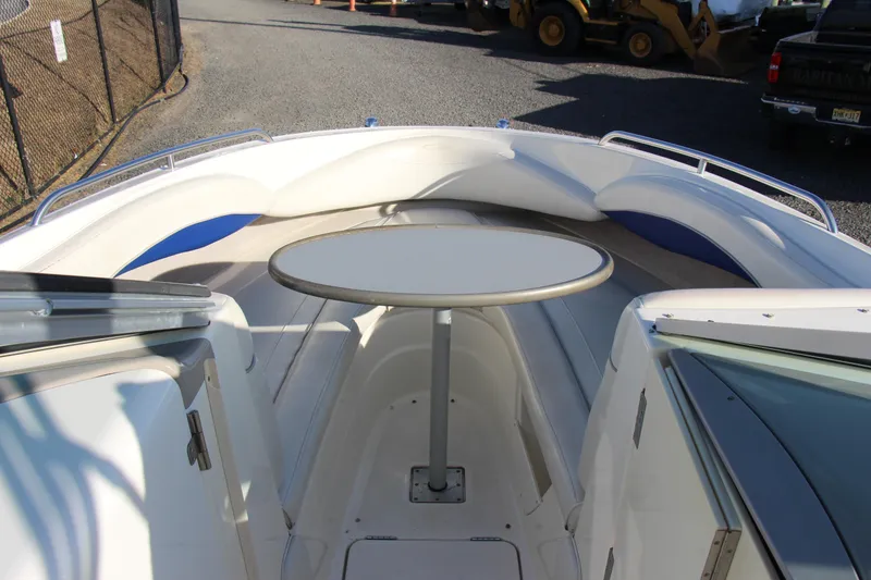 Slide: The Image of 2004 Maxum 2400 SR boat interior with round table and seating area. - 14