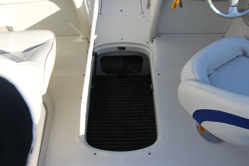 Slide: The Image of 2004 Maxum 2400 SR boat interior with open storage compartment and seating. - 18