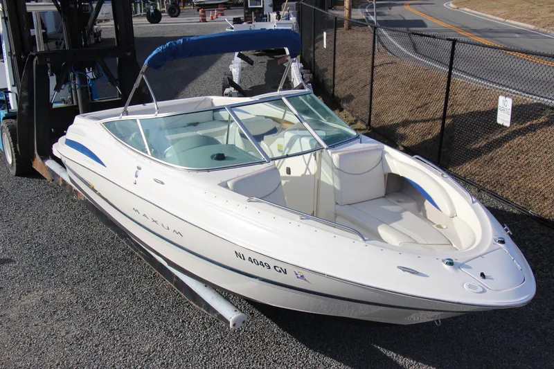 Slide: The Image of 2004 Maxum 2400 SR boat with blue canopy on gravel lot. - 3