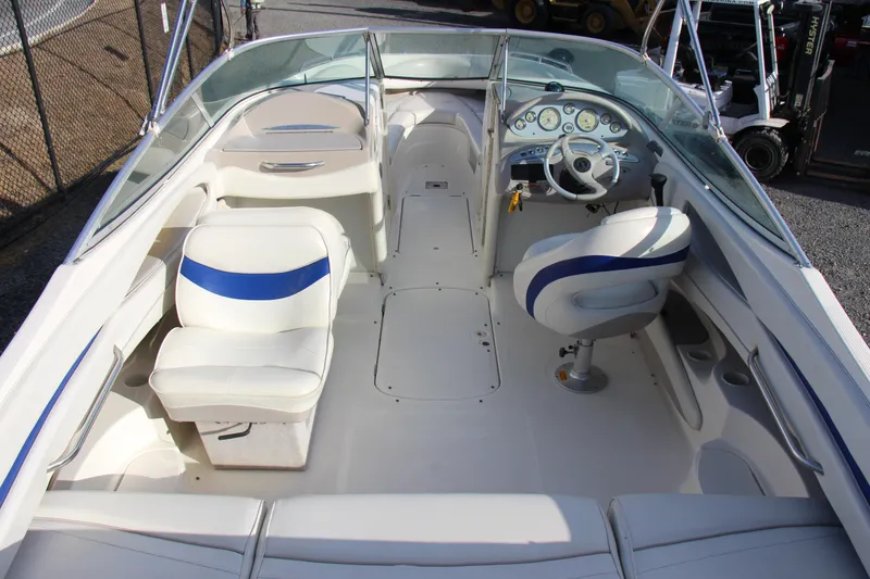 Slide: The Image of 2004 Maxum 2400 SR boat interior with white and blue seating, steering wheel, and dashboard. - 7