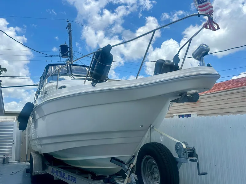 The Image of 2001 Regal Commodore 2760 boat on trailer, American flag, clear sky background. - 0