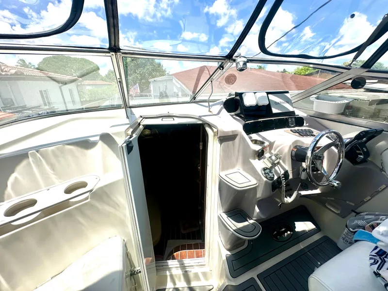 Slide: The Image of 2001 Regal Commodore 2760 boat cockpit with steering wheel, navigation equipment, and open cabin door. - 17