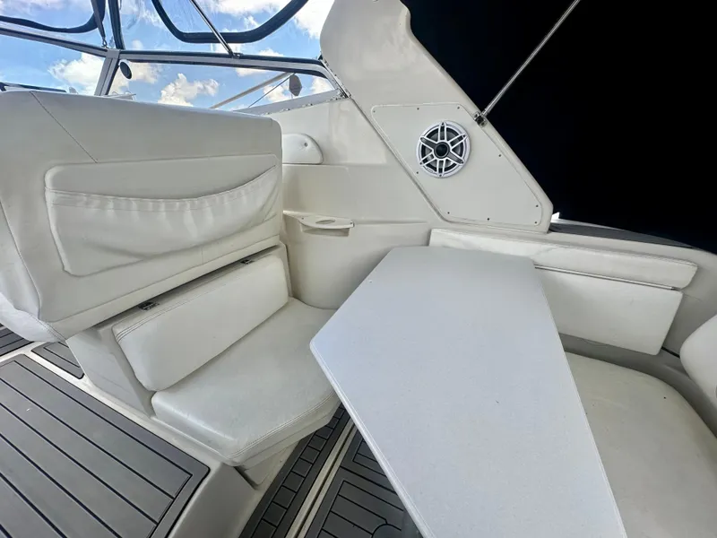 Slide: The Image of 2001 Regal Commodore 2760 boat interior with white seating and table, featuring a speaker. - 25