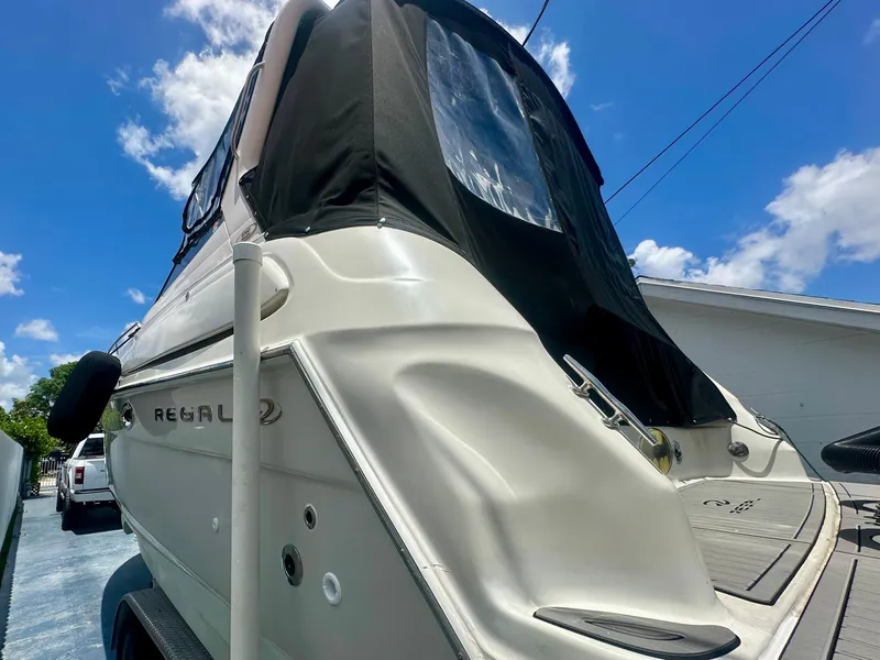Slide: The Image of 2001 Regal Commodore 2760 boat with black canopy under a clear blue sky. - 38