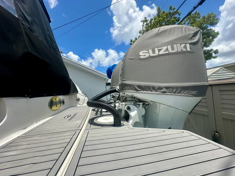 Slide: The Image of 2001 Regal Commodore 2760 boat with Suzuki engine cover, docked under a blue sky. - 42