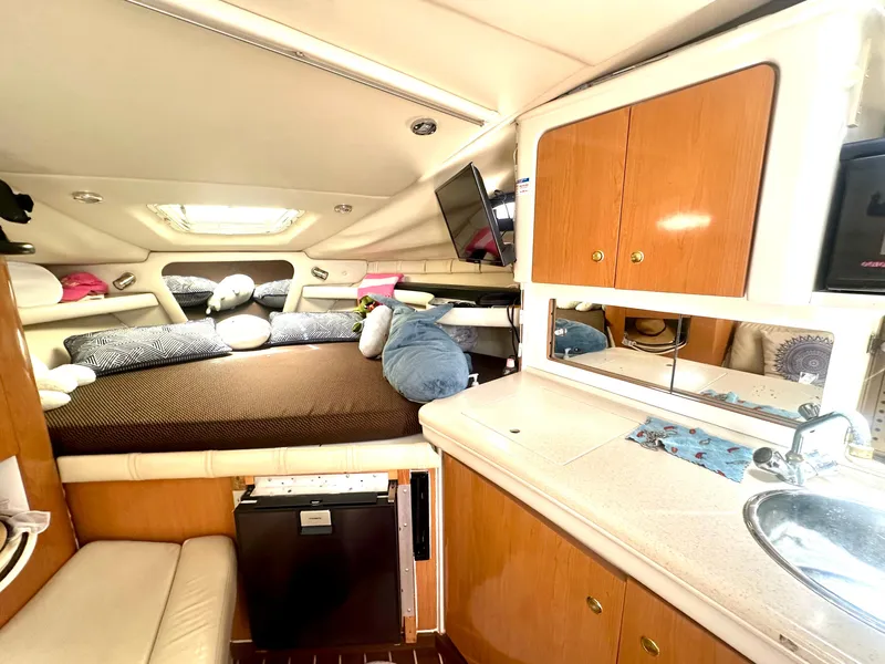 Slide: The Image of 2001 Regal Commodore 2760 cabin interior with bed, kitchenette, and storage cabinets. - 48
