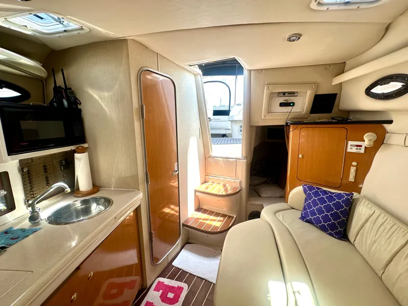 Slide: The Image of Interior of 2001 Regal Commodore 2760 boat with kitchenette, seating, and steps to deck. - 49