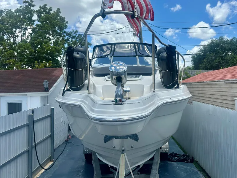 Slide: The Image of 2001 Regal Commodore 2760 boat on trailer, parked in driveway, with American flag. - 5