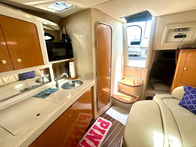 Slide: The Image of 2001 Regal Commodore 2760 interior with kitchenette, sink, microwave, and cozy seating area. - 50