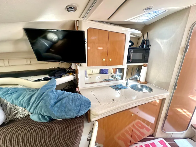 Slide: The Image of 2001 Regal Commodore 2760 cabin interior with kitchenette, TV, and plush shark toy. - 53